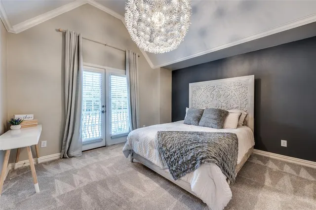 a spacious bedroom with a bed and a chandelier
