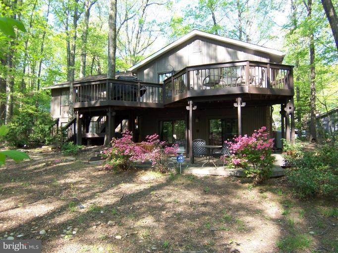 2407 Sugarberry Court Reston, VA 20191 - Photo 3 of 24 a view of a house with a lot of flower plants and wooden fence