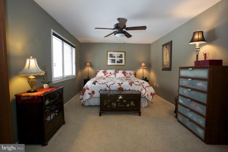 2407 Sugarberry Court Reston, VA 20191 - Photo 8 of 24 a bedroom with a bed and a lamp on dresser