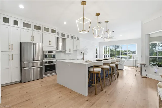 a kitchen with stainless steel appliances granite countertop a table chairs stove and refrigerator