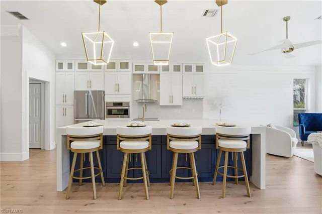 a view of a dining room and livingroom with furniture wooden floor a chandelier