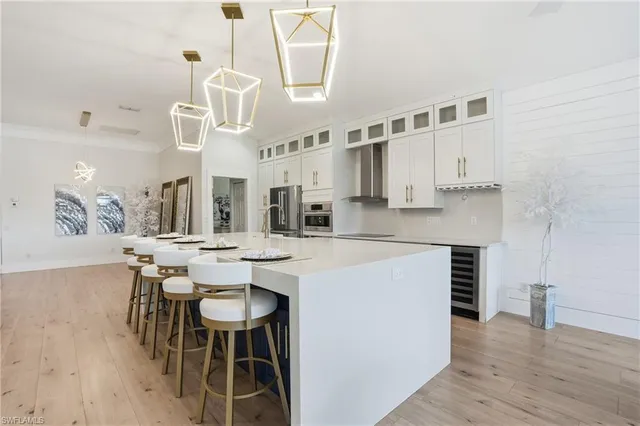 a kitchen with a dining table chairs and white cabinets