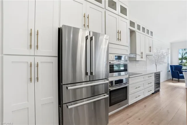 a kitchen with stainless steel appliances a refrigerator stove and cabinets