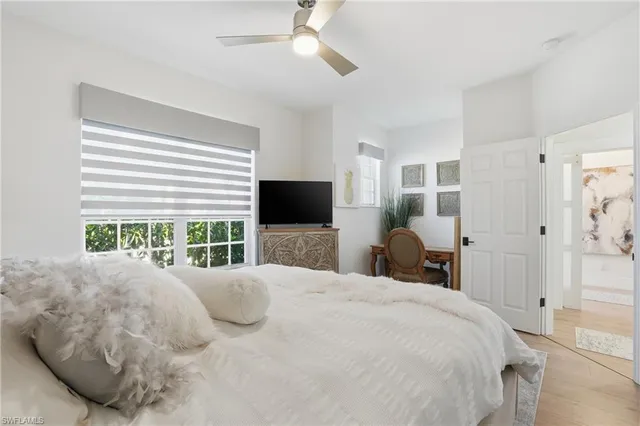 a bedroom with a large bed and a flat tv screen