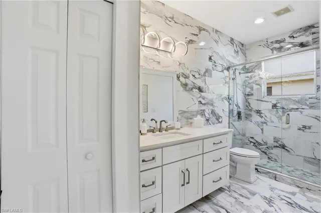 a bathroom with a double vanity sink mirror and toilet