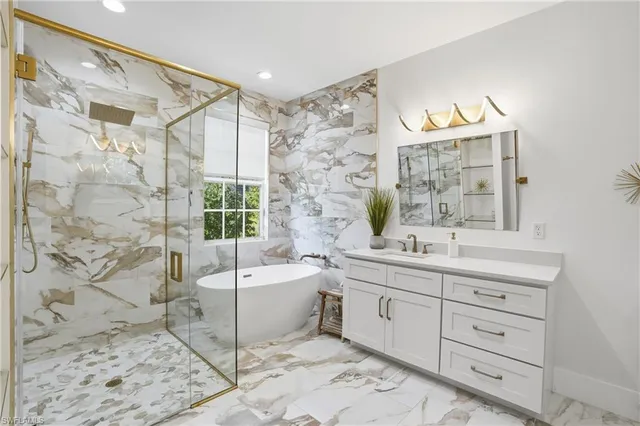 a spacious bathroom with a double vanity sink mirror and bathtub
