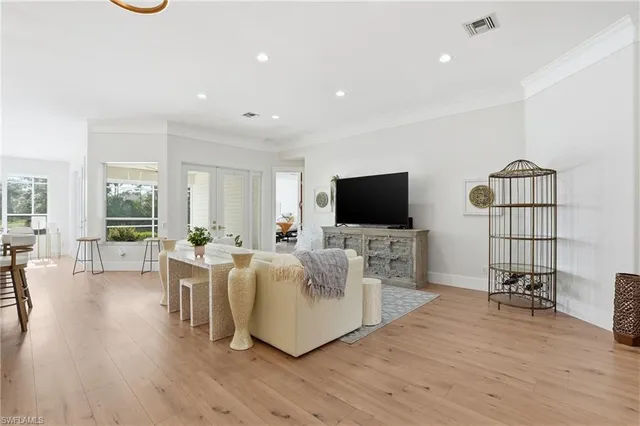 a living room with furniture a flat screen tv and a flat screen tv