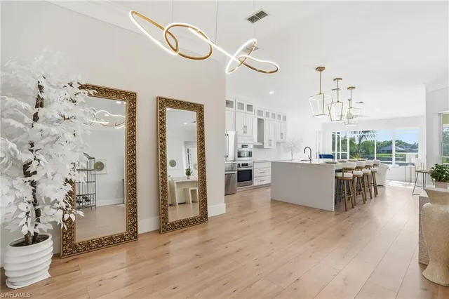 a large kitchen with cabinets a sink a window and stainless steel appliances