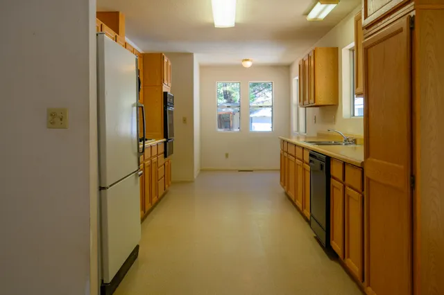 a kitchen with stainless steel appliances a refrigerator a stove a microwave a sink and cabinets