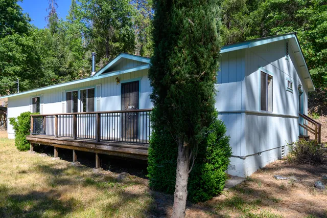 a view of a house with wooden deck and a yard