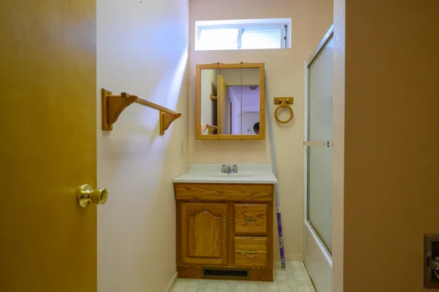a view of an empty room with window and ceiling fan