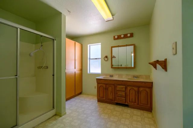 a spacious bathroom with a mirror a sink and shower
