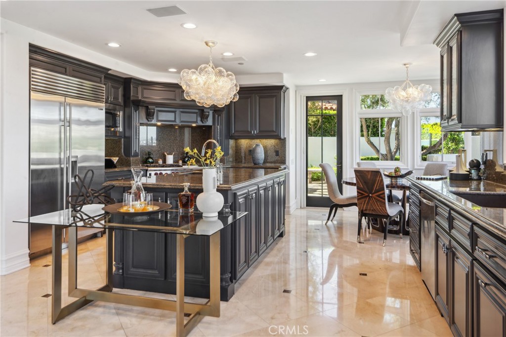 28 Shoreridge Newport Coast, CA 92657 - Photo 19 of 75 a kitchen filled with stainless steel appliances granite countertop a stove top oven a refrigerator a dining table and chairs with wooden floor