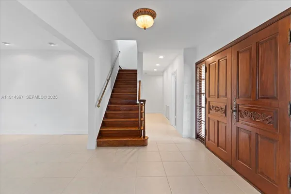a view of a hallway with entryway wooden floor and cabinet