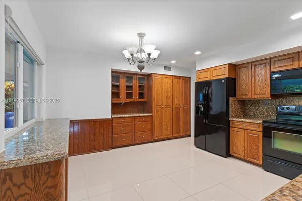 a kitchen with stainless steel appliances granite countertop a refrigerator and a sink