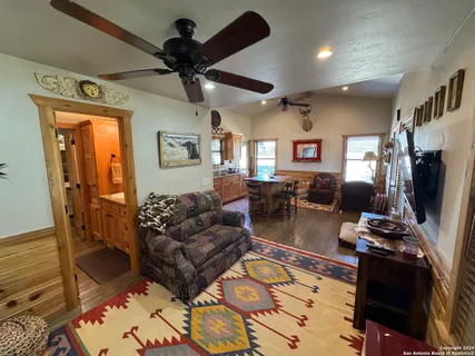 a living room with furniture a flat screen tv and a table