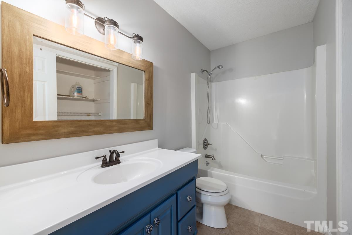3604 Star Trek Court Raleigh, NC 27604 - Photo 17 of 24 a bathroom with a toilet a sink a mirror a bathtub and vanity
