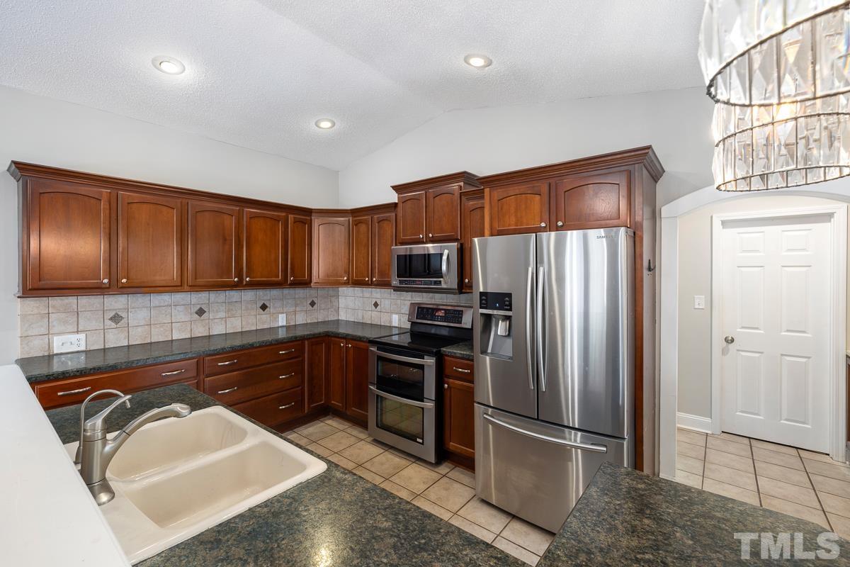 3604 Star Trek Court Raleigh, NC 27604 - Photo 6 of 24 a kitchen with stainless steel appliances granite countertop a refrigerator and a sink
