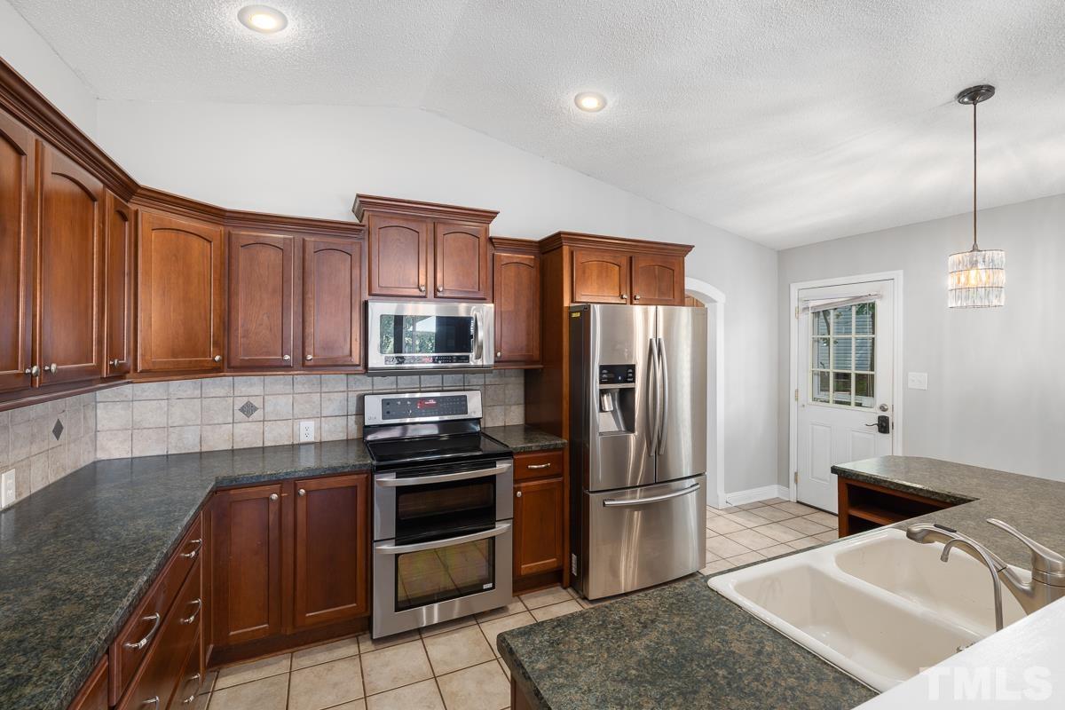 3604 Star Trek Court Raleigh, NC 27604 - Photo 7 of 24 a kitchen with stainless steel appliances granite countertop a refrigerator a stove a sink and a microwave