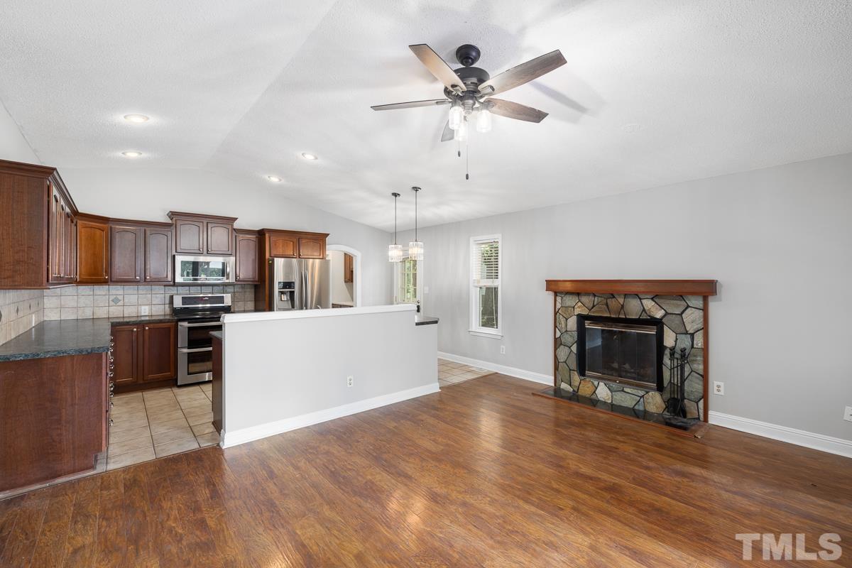 3604 Star Trek Court Raleigh, NC 27604 - Photo 9 of 24 a view of a kitchen with a stove wooden cabinets and a fireplace