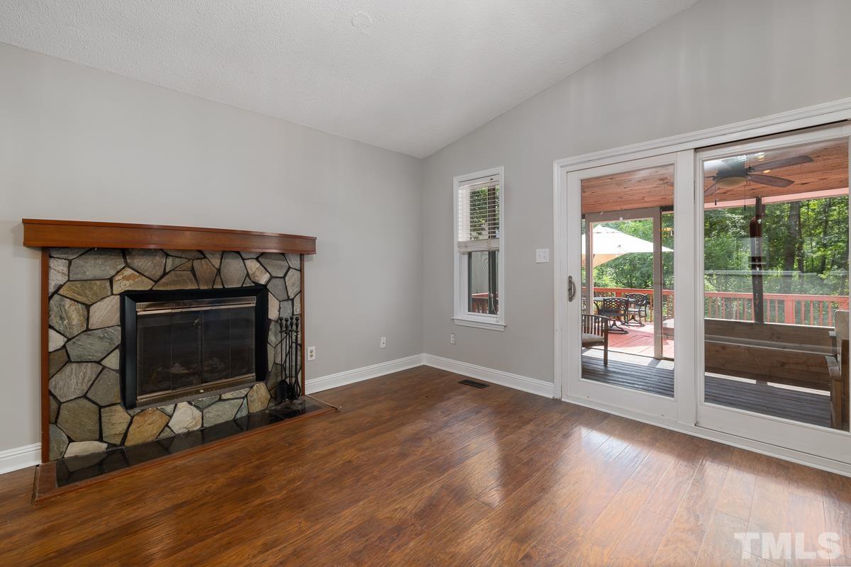 3604 Star Trek Court Raleigh, NC 27604 - Photo 10 of 24 a living room with a fireplace and a floor to ceiling window
