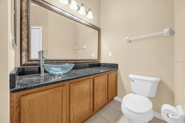 a bathroom with a granite countertop toilet sink and mirror