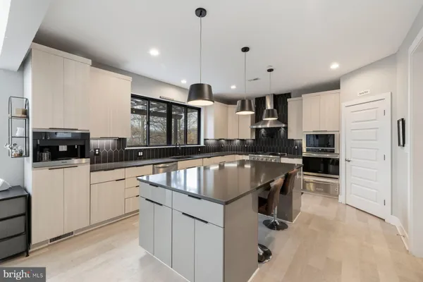 a kitchen with stainless steel appliances granite countertop a sink a stove and a refrigerator