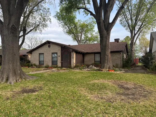 a view of a house with a yard and large tree