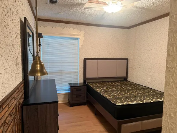 a bed sitting in a bedroom next to a window