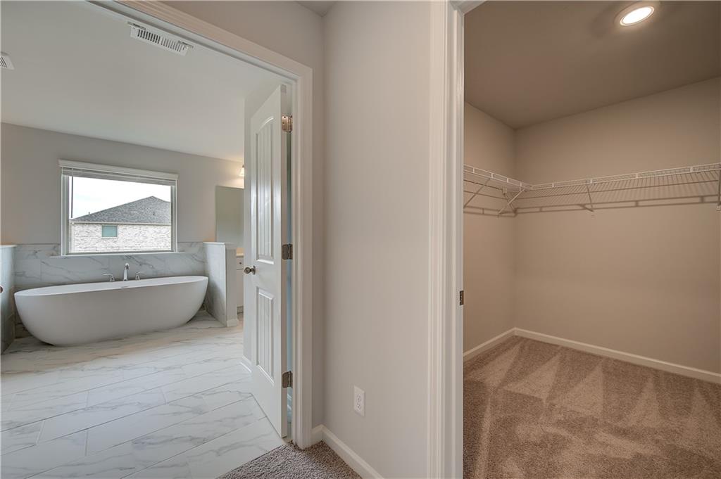 343 Linford Drive Locust Grove, GA 30248 - Photo 29 of 36 a bathroom with a tub and mirror