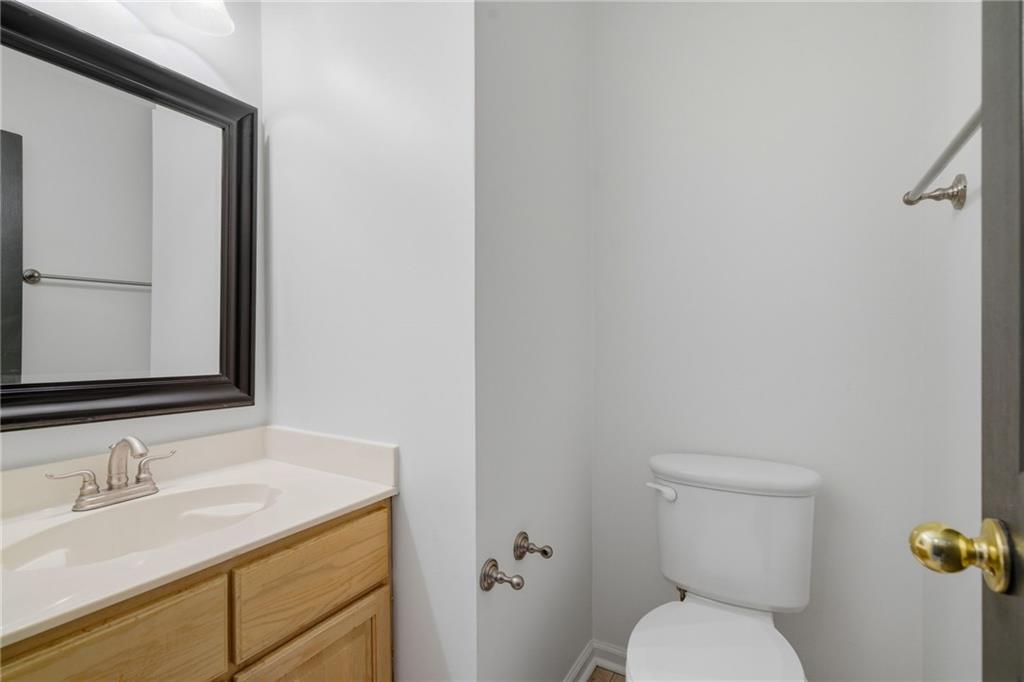 5868 Valine Way Sugar Hill, GA 30518 - Photo 11 of 32 a bathroom with a granite countertop toilet sink and mirror