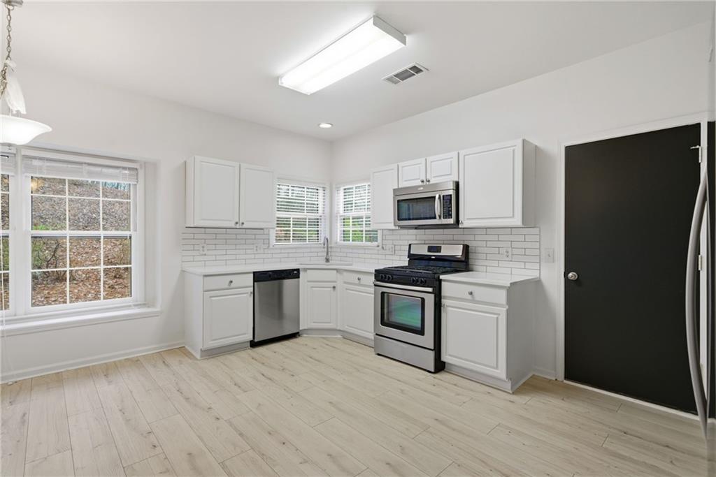 5868 Valine Way Sugar Hill, GA 30518 - Photo 13 of 32 a kitchen with granite countertop a refrigerator stove top oven and sink
