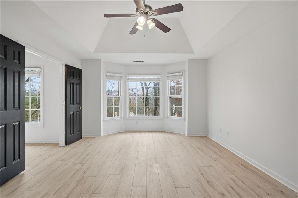 5868 Valine Way Sugar Hill, GA 30518 - Photo 16 of 32 a view of an empty room with wooden floor and a window