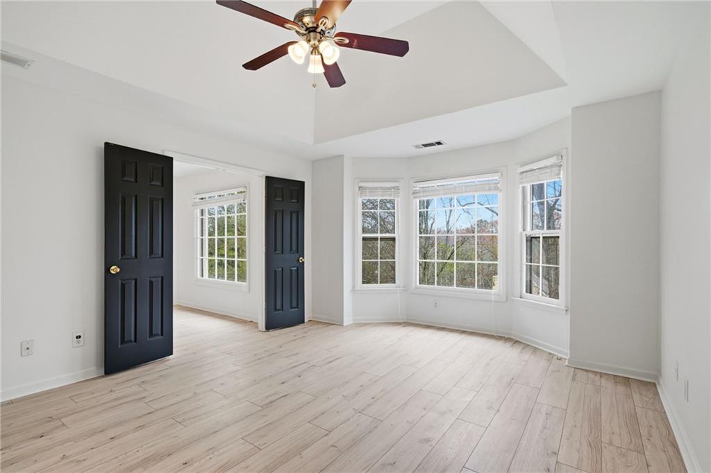 5868 Valine Way Sugar Hill, GA 30518 - Photo 17 of 32 a view of an empty room with a window and wooden floor