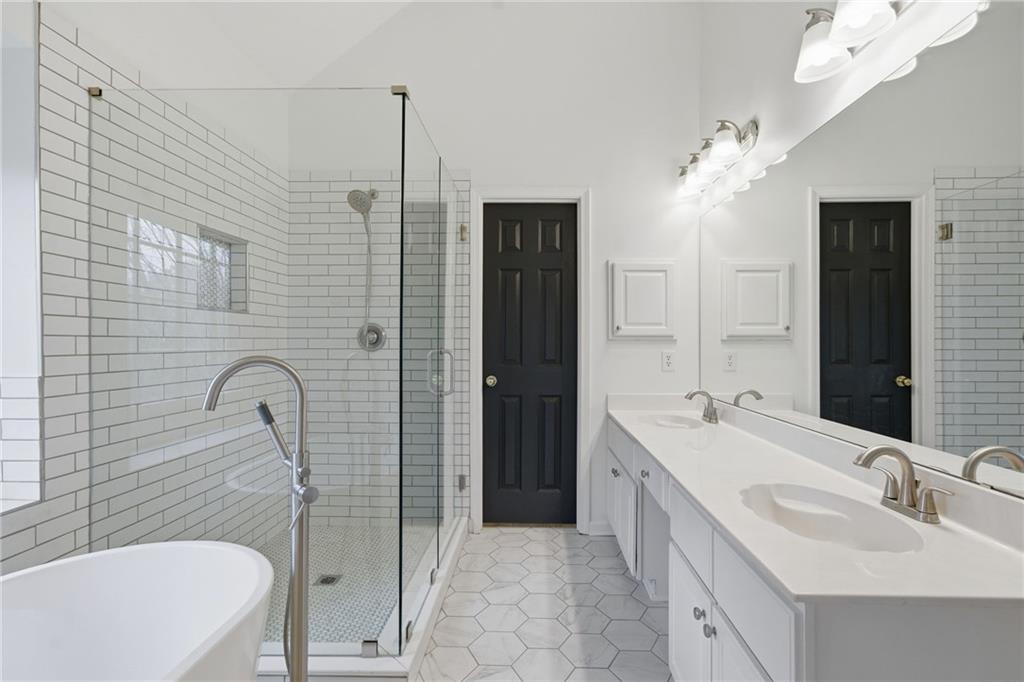 5868 Valine Way Sugar Hill, GA 30518 - Photo 18 of 32 a bathroom with a tub sink and mirror