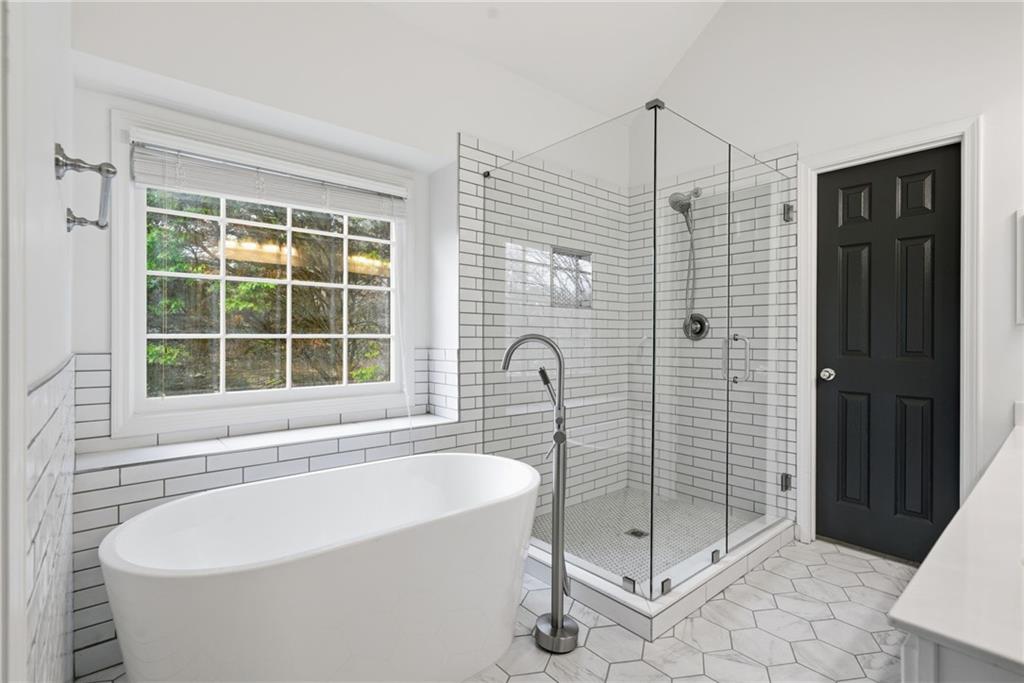 5868 Valine Way Sugar Hill, GA 30518 - Photo 19 of 32 a bathroom with a bathtub and shower