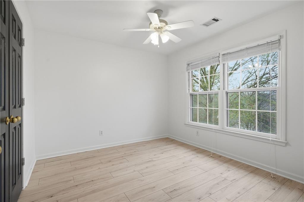 5868 Valine Way Sugar Hill, GA 30518 - Photo 21 of 32 an empty room with wooden floor and windows