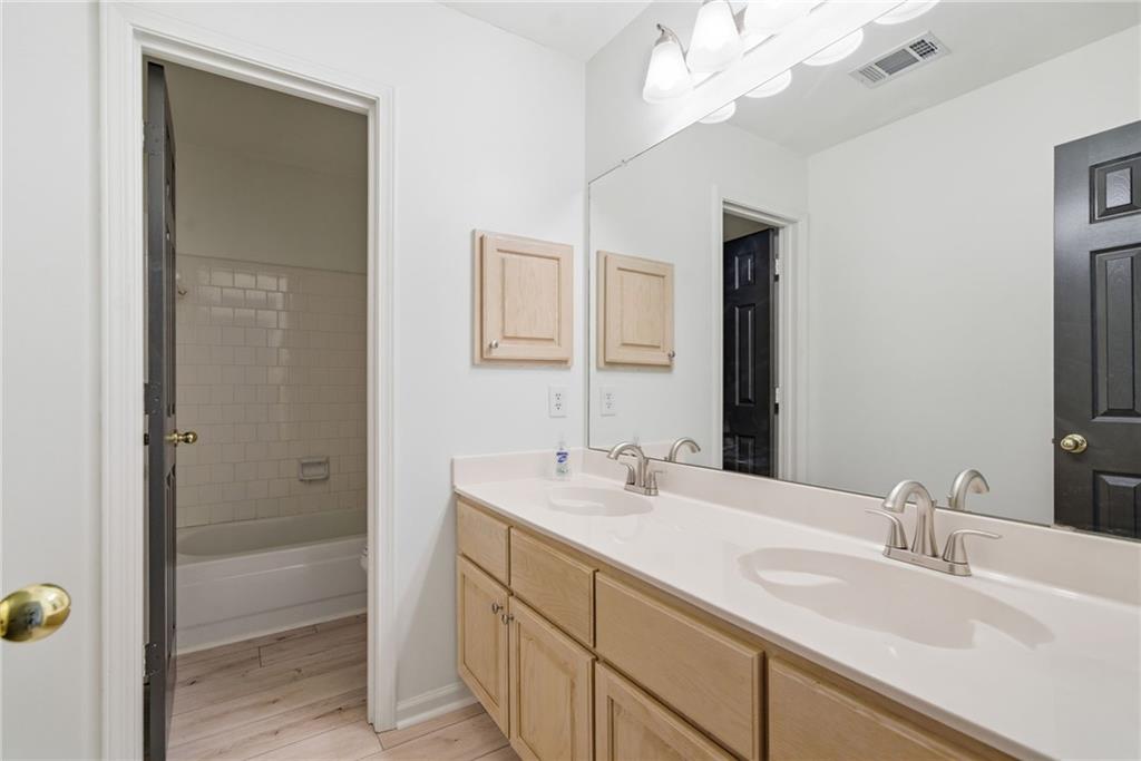 5868 Valine Way Sugar Hill, GA 30518 - Photo 22 of 32 a bathroom with a sink a vanity and a mirror
