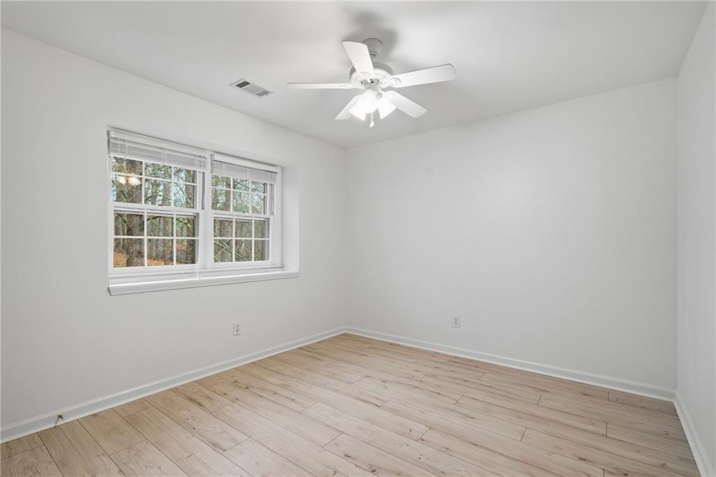 5868 Valine Way Sugar Hill, GA 30518 - Photo 23 of 32 an empty room with wooden floor and windows