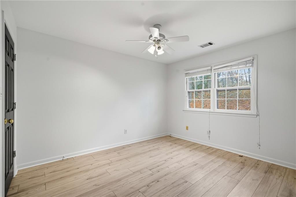 5868 Valine Way Sugar Hill, GA 30518 - Photo 24 of 32 a view of an empty room with wooden floor and a window