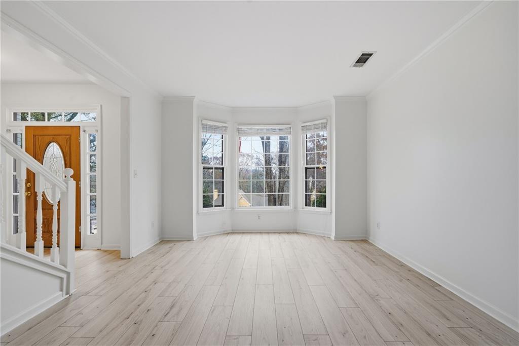 5868 Valine Way Sugar Hill, GA 30518 - Photo 7 of 32 wooden floor in an empty room with a window