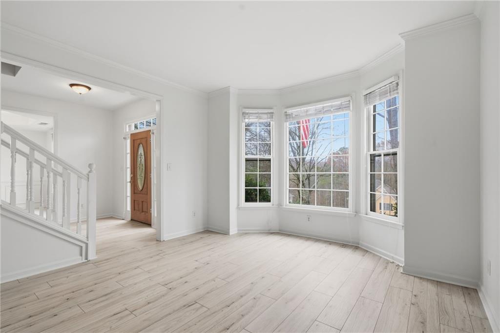 5868 Valine Way Sugar Hill, GA 30518 - Photo 8 of 32 a view of an empty room with wooden floor and a window