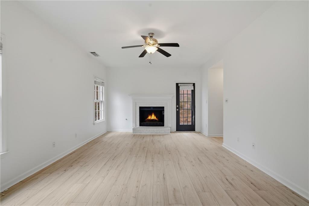 5868 Valine Way Sugar Hill, GA 30518 - Photo 9 of 32 a view of an empty room with a fireplace and a window