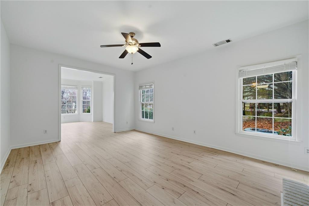 5868 Valine Way Sugar Hill, GA 30518 - Photo 10 of 32 a view of empty room with wooden floor and fan