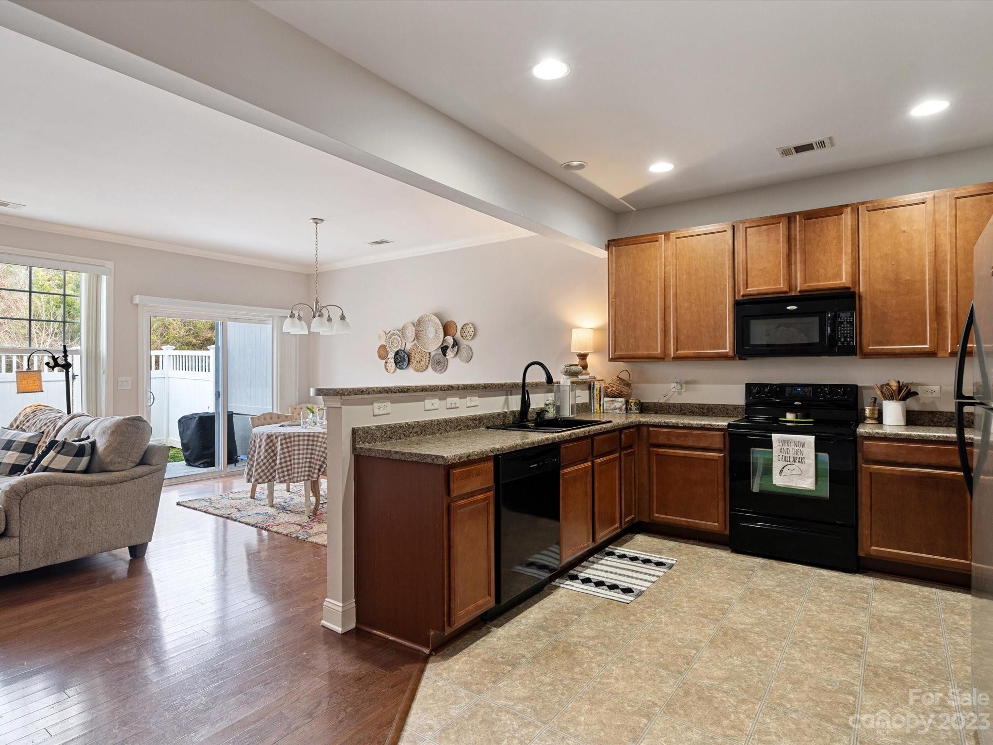 256 River Clay Road Fort Mill, SC 29708 - Photo 6 of 41 a kitchen with stainless steel appliances kitchen island granite countertop a stove top oven a sink dishwasher a dining table and chairs with wooden floor