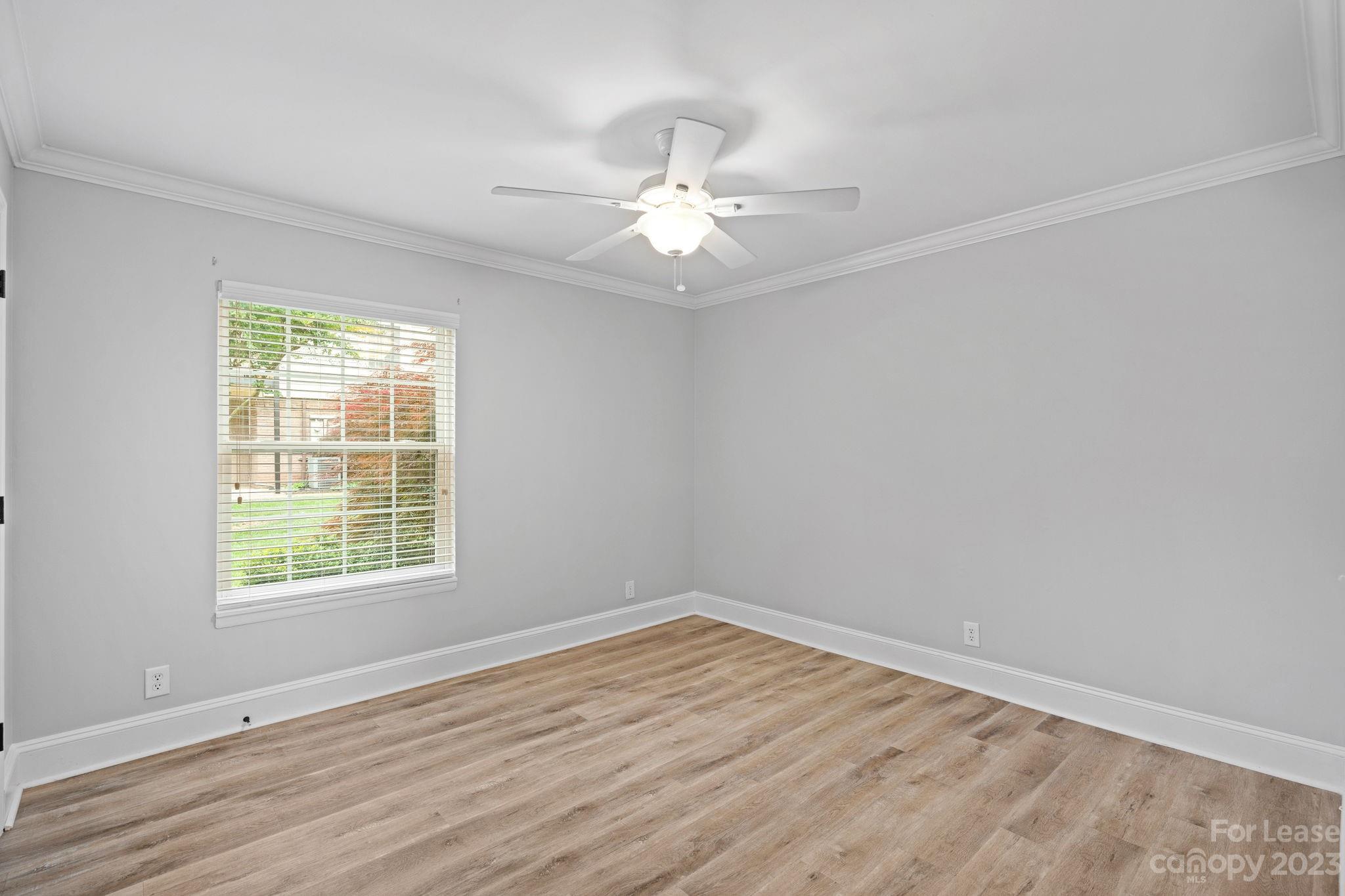 2614 Park Road Charlotte, NC 28209 - Photo 11 of 19 an empty room with wooden floor ceiling fan and windows