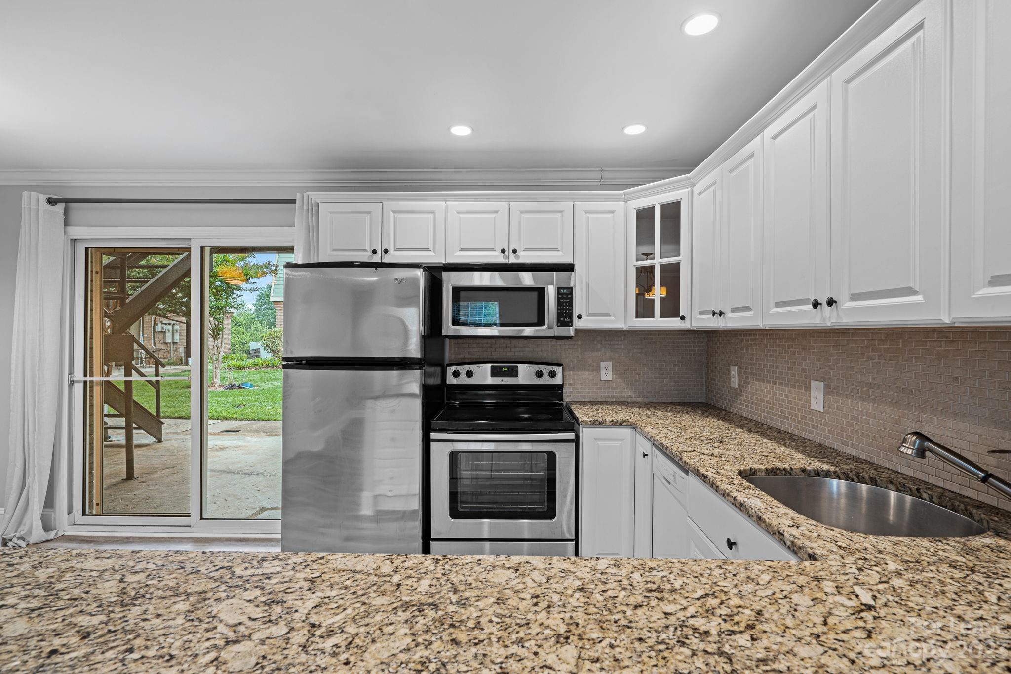 2614 Park Road Charlotte, NC 28209 - Photo 4 of 19 a kitchen with stainless steel appliances granite countertop a stove a microwave and a sink