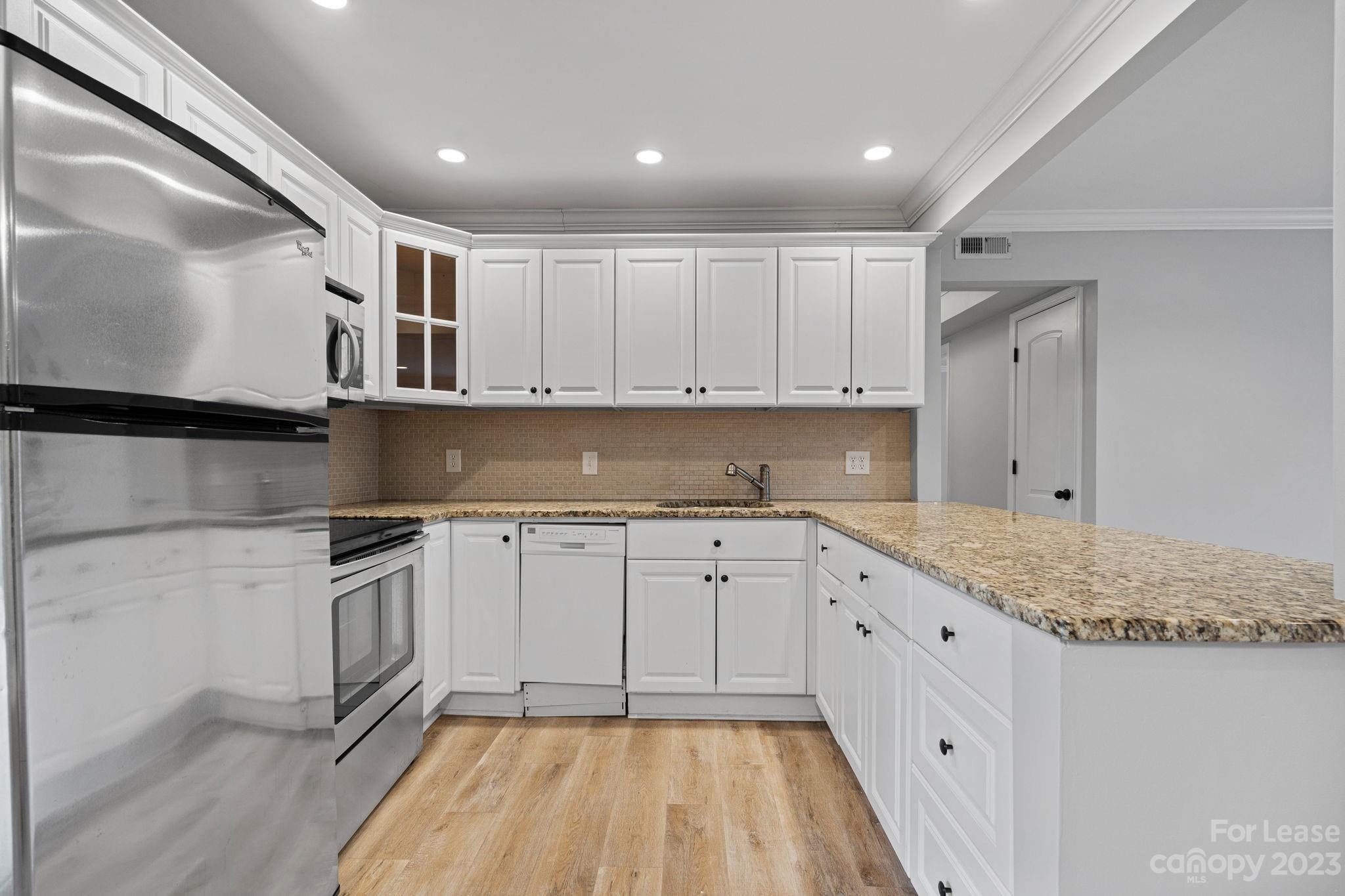 2614 Park Road Charlotte, NC 28209 - Photo 5 of 19 a kitchen with granite countertop white cabinets and stainless steel appliances