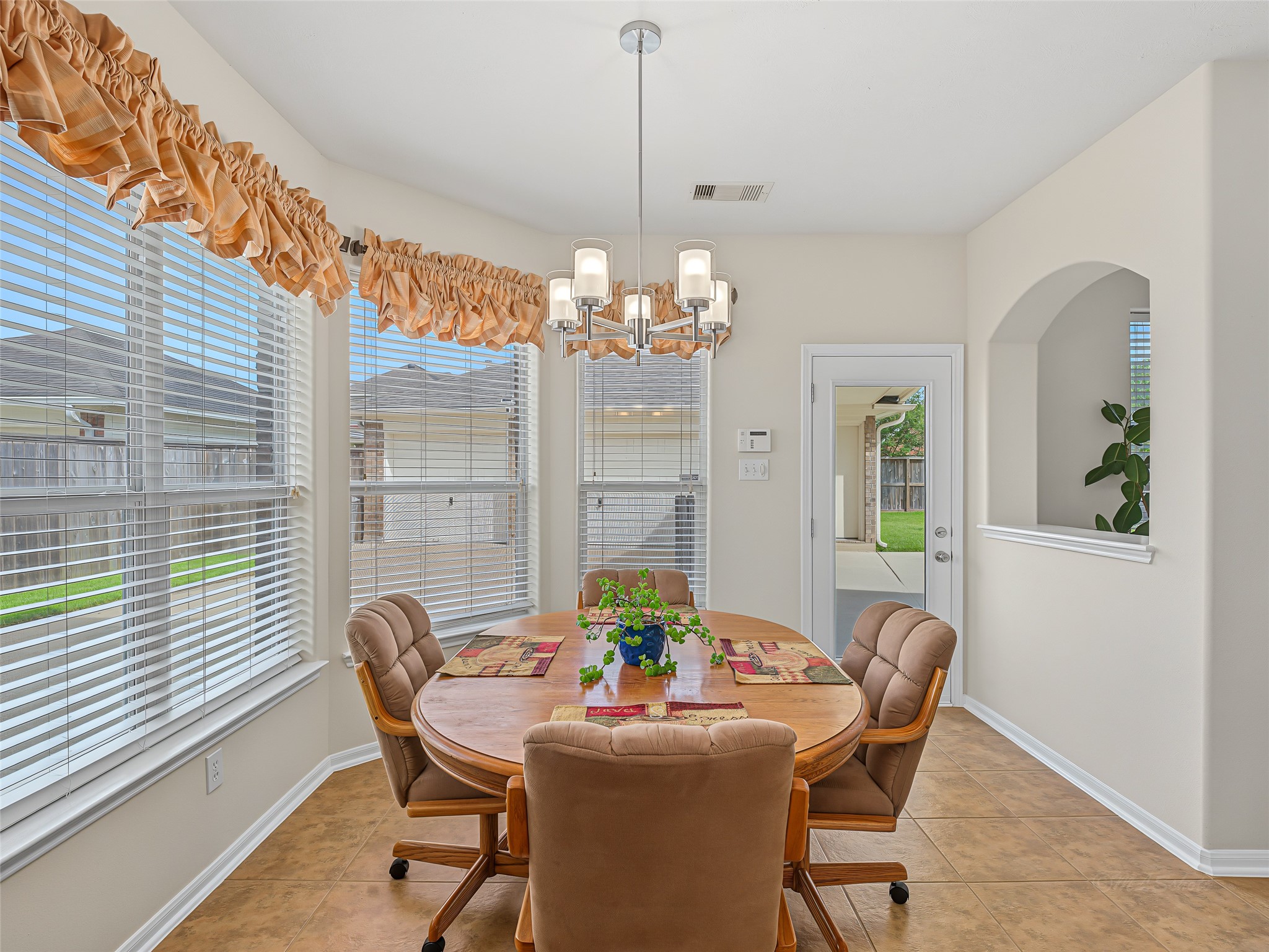 2210 Fox Path Katy, TX 77494 - Photo 18 of 47 A classic arched interior cutout connects the space to the family room for an enhanced open-concept feel, while the adjacent glass-paneled back door provides effortless access to the outdoor patio for convenient indoor-outdoor living.