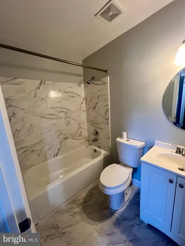 a kitchen with stainless steel appliances granite countertop a refrigerator a sink dishwasher a stove and white countertops with wooden floor